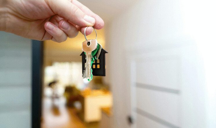Chave de imóvel sendo entregue após regularização da propriedade, ilustrando o procedimento de adjudicação compulsória extrajudicial.